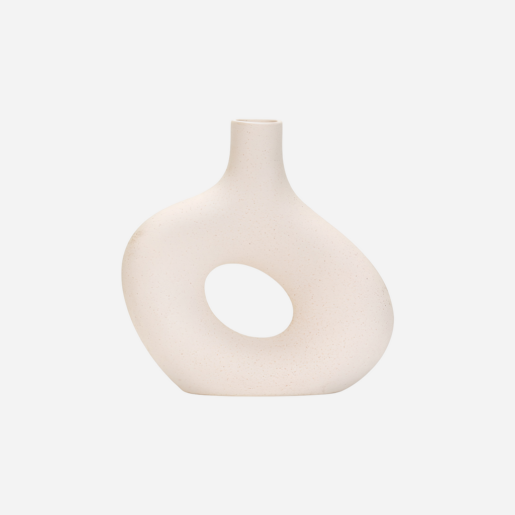 White vase with a circular design on a light gray background