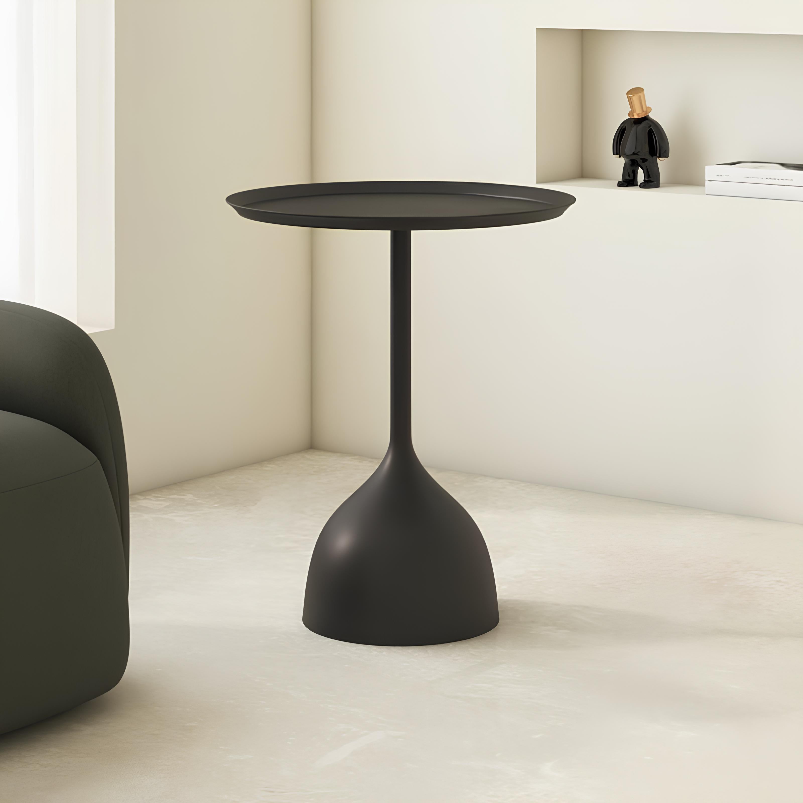 Black side table in a minimalistic room with a chair and small figure.