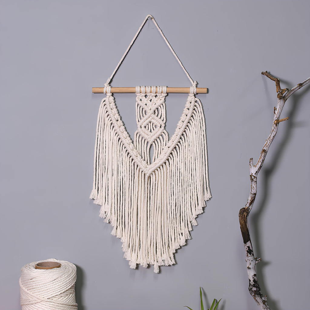 Macrame wall hanging with fringes on a gray background